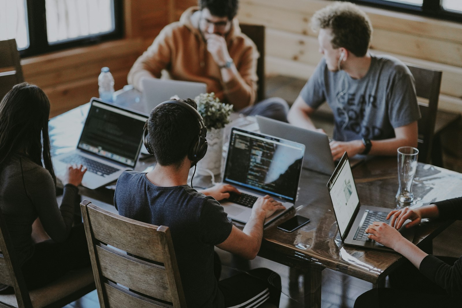 Group of colleagues gathered around a laptop, working together as a small startup team
